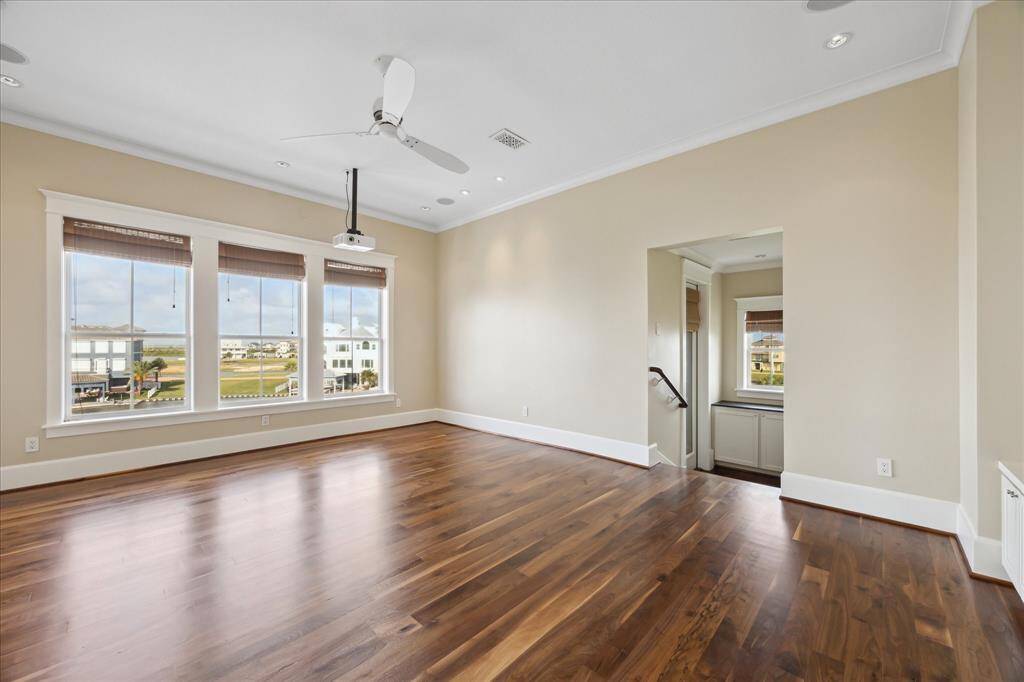 This second view of the movie room reveals a staircase leading down to an additional storage room, combining entertainment and functionality in one thoughtfully designed space