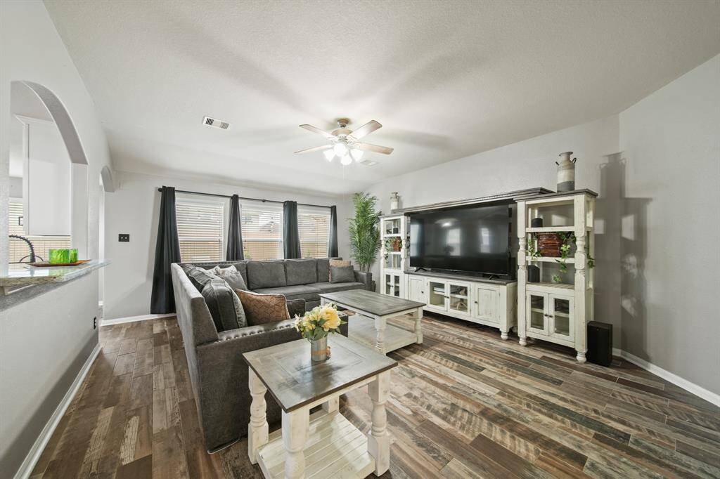 A granite surfaced breakfast/serving bar highlighted by an arched opening above sits just between the kitchen & living room.