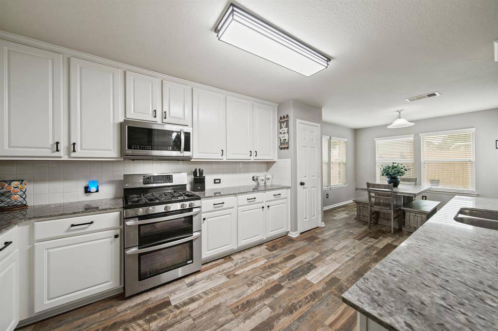The stainless steel appliance package includes a 5-burner gas range with double ovens below, built-in microwave oven with lighting & ventilation above and a new dishwasher installed in 2025. As an added bonus, the Samsung French door refrigerator with door mounted ice & water dispenser purchased in 2022 is included!