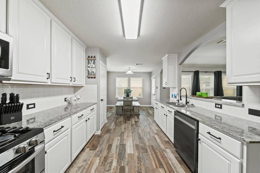 A view of the kitchen with the breakfast room in the background.