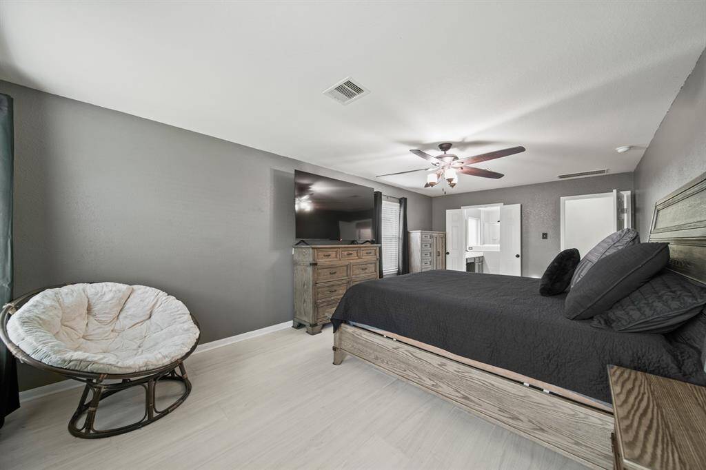 Features include multiple windows with binds & drapes, a ceiling fan with lighting & hardwood tile floors.