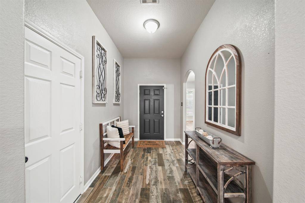 Included is access to the home's two car attached garage and the arched opening on the right leads to the secondary bedrooms with access to the home's second full bath. The attic of the home was re-decked in 2021-2022.