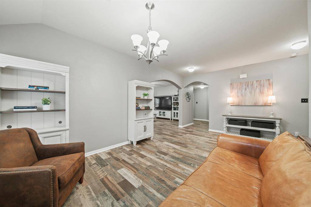 A view of the foyer from the back of the dining room and through the archway is the laundry room and primary bedroom.