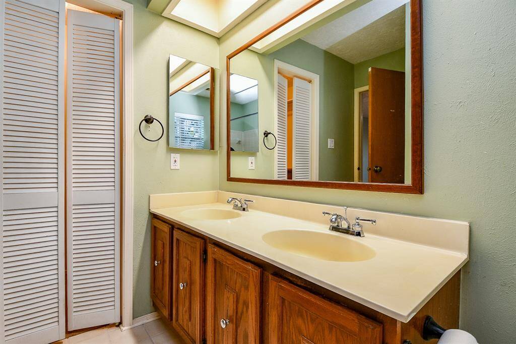 Primary bath with dual sinks and a large mirror directly next to your walk-in closet.