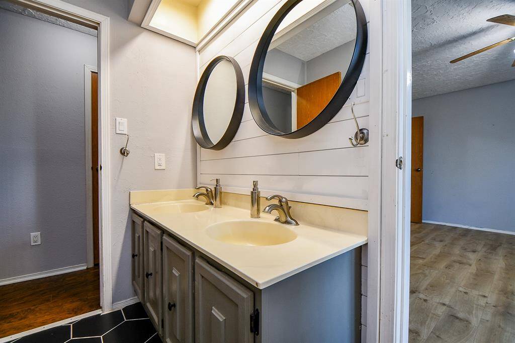 Secondary bathroom includes updated sinks and flooring.