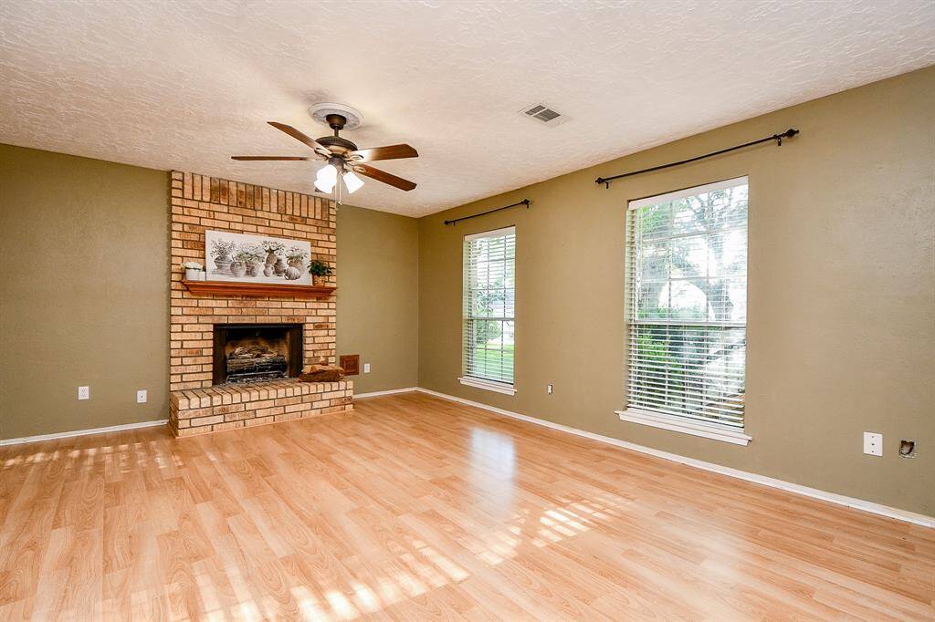 Ample lighting from front windows accentuates the  beautiful floors.