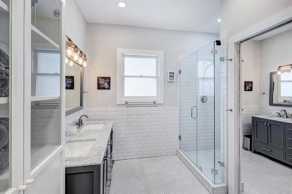 Downstairs primary bathroom is well-appointed with marble counter, double sinks and walk-in shower.