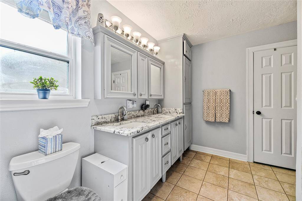 Primary bathroom with a stunning dual sink granite vanity.