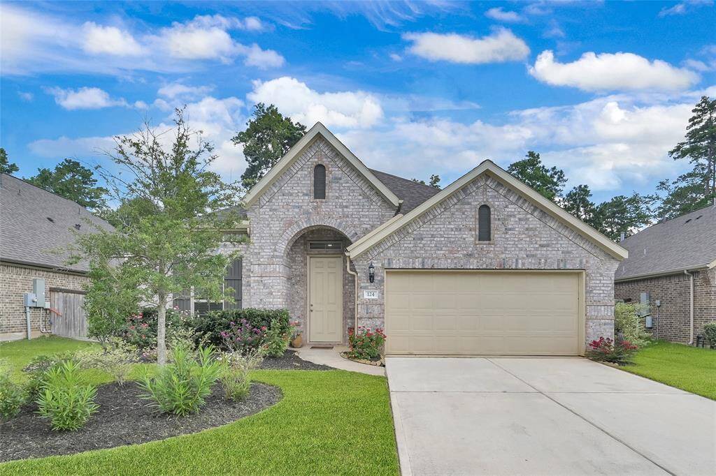 Charming brick home with great curb appeal, featuring a covered entry, two-car garage, and vibrant rose bushes that beautifully accent the landscaped front yard.