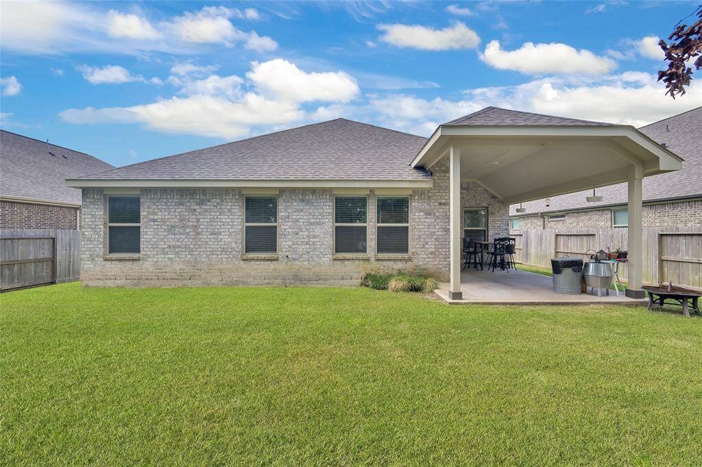 Spacious backyard with lush greenery, a covered patio for outdoor entertaining, full fencing for privacy, and no rear neighbors—offering a serene and private retreat.