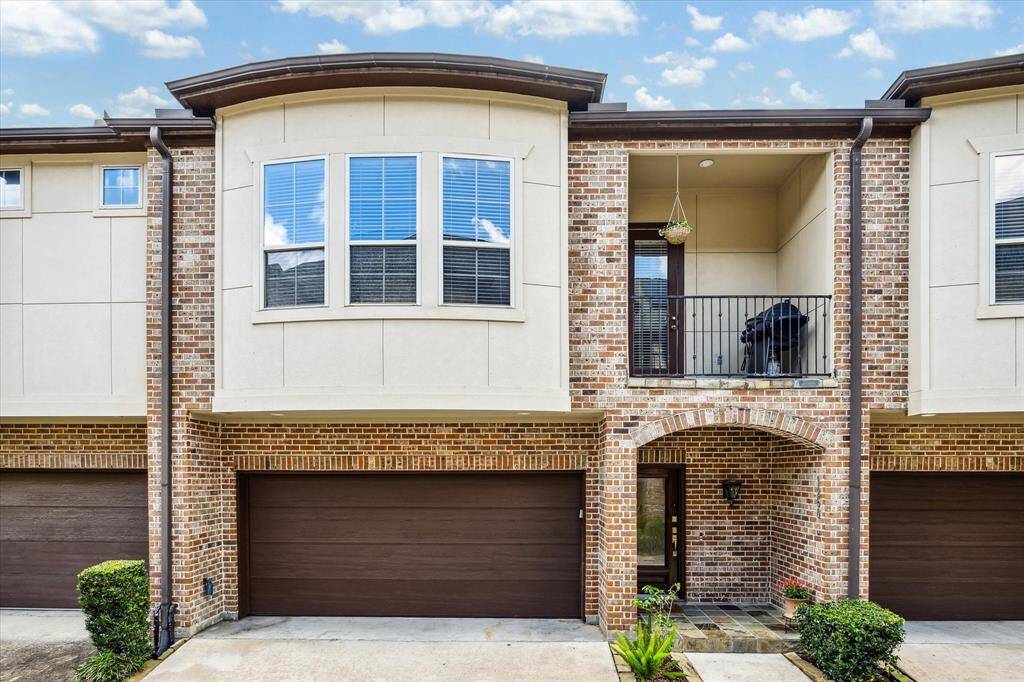 This charming two-story home features a blend of cement board and brick exterior, with a spacious balcony adding to its appeal. A two-car garage completes the property, offering classic style and modern comfort.