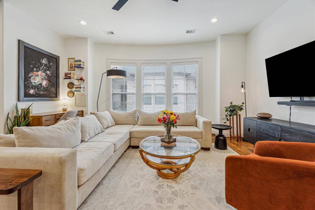 This cozy second-floor living room is designed for comfort and style, featuring a modern matte black ceiling fan that adds a sleek touch. The open layout offers a perfect space for relaxation and entertaining, with natural light enhancing the inviting atmosphere.