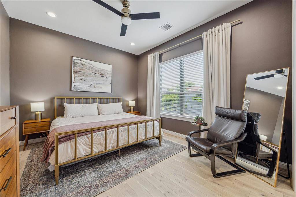 This spacious primary bedroom, located on the second floor, boasts hardwood floors (2024) throughout the bedroom and closet. Neutral designer wall paint enhances the serene atmosphere, while recessed LED lighting adds a modern touch.