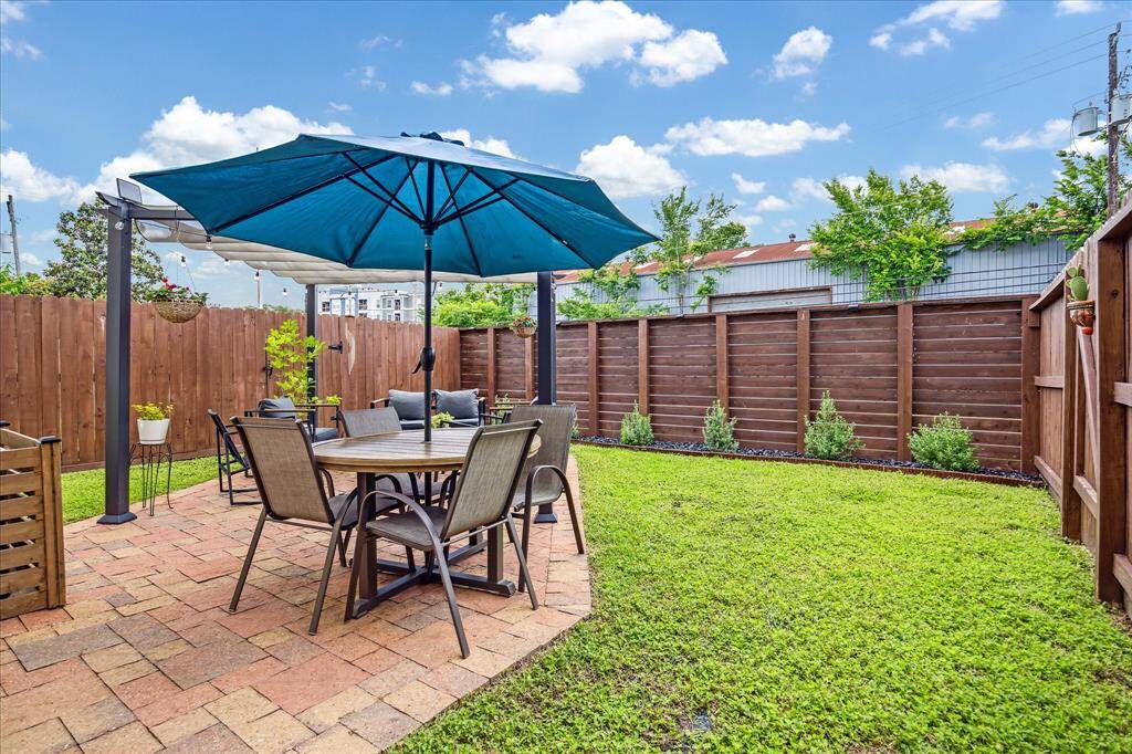 Step into a beautifully landscaped backyard filled with greenery and thoughtfully placed plants that enhance the outdoor ambiance. The back patio is shaded by a charming pergola, ideal for relaxing or entertaining. Stained wood fencing surrounds the space, providing both style and seclusion.