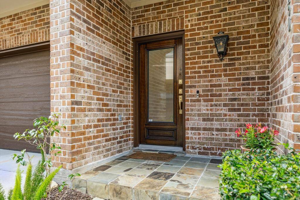 The beautiful front exterior boasts an elegant arched brick entryway, creating a warm and inviting first impression. A covered front porch adds charm and provides a perfect spot to relax and enjoy the outdoors.