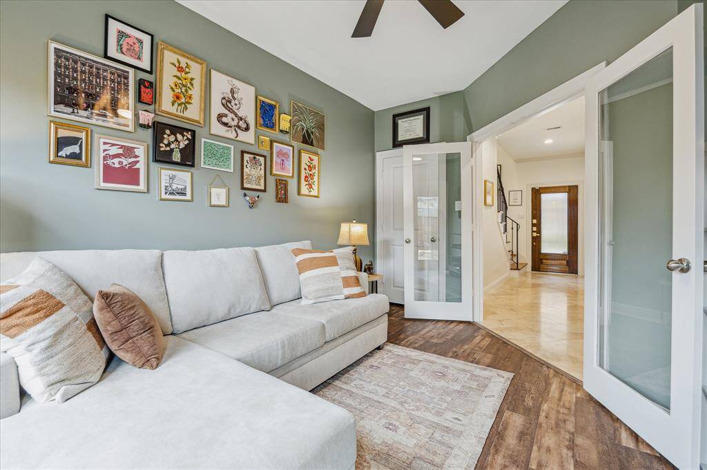 The modern matte black ceiling fan adds a sleek touch to the room. The French doors allow natural light to fill the space and provide easy access to outdoor living.