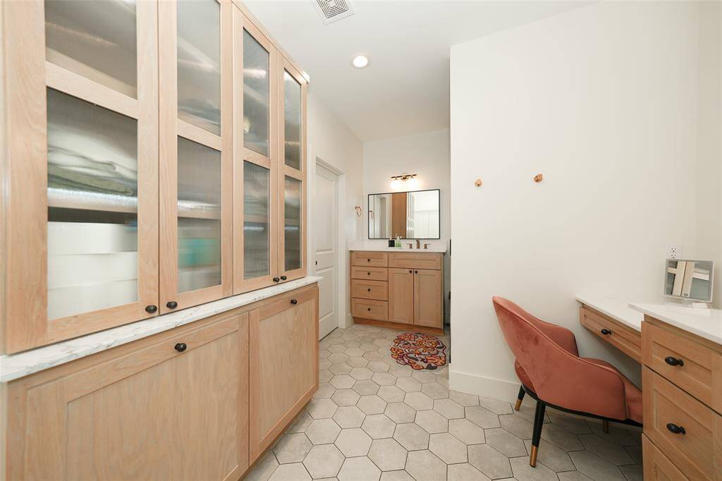 Spacious and stylish — this open-concept living room features custom floating shelves and a sleek gas fireplace