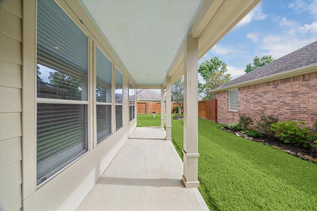 Lovely view of side yard, gate and covered back porch.