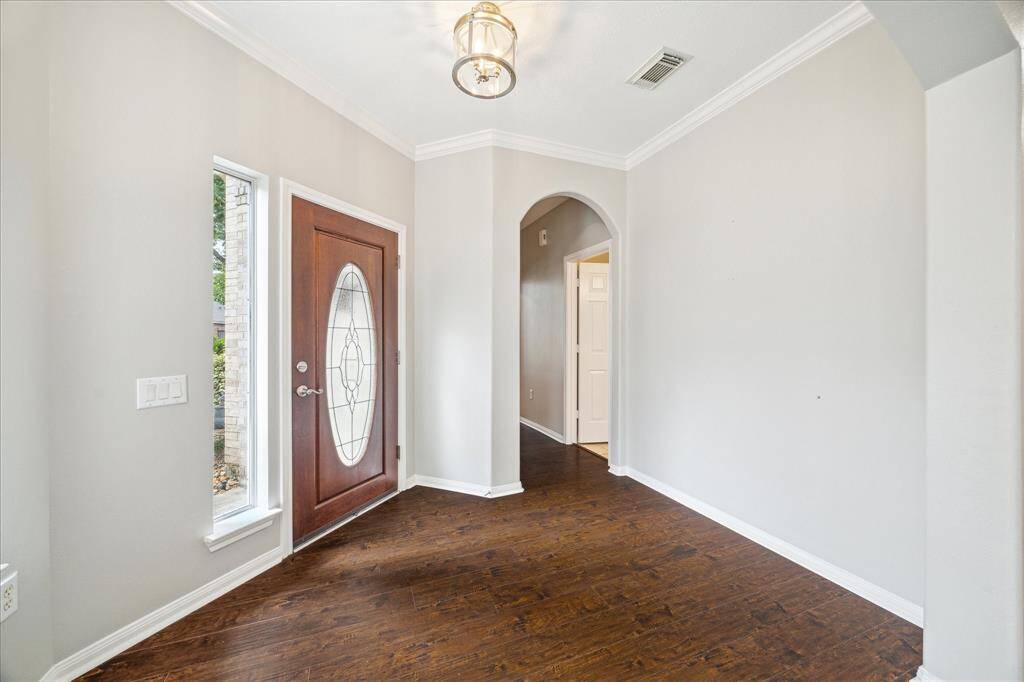 Foyer in background opens to the open plan Great Room concept with view here to Dining area and breakfast bar at right.