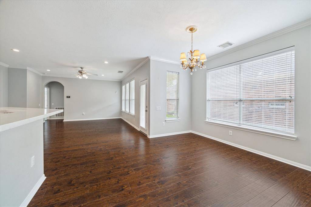 Beautiful wall of windows overlooks the back covered patio and flowering side garden.