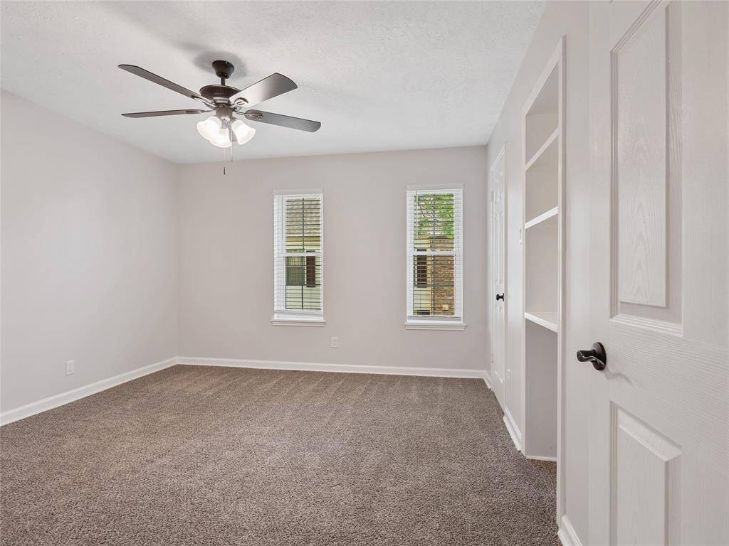 Secondary bedroom upstairs with new blinds and a built in bookshelf