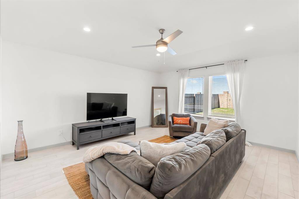 Open family room with high ceilings recessing lighting, beautiful tile flooring with the exception of the bedrooms