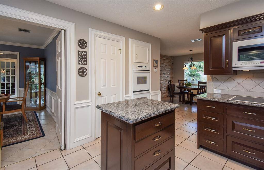 All common areas seamlessly link in this view, with spacious breakfast nook, right, and formal dining area, left.