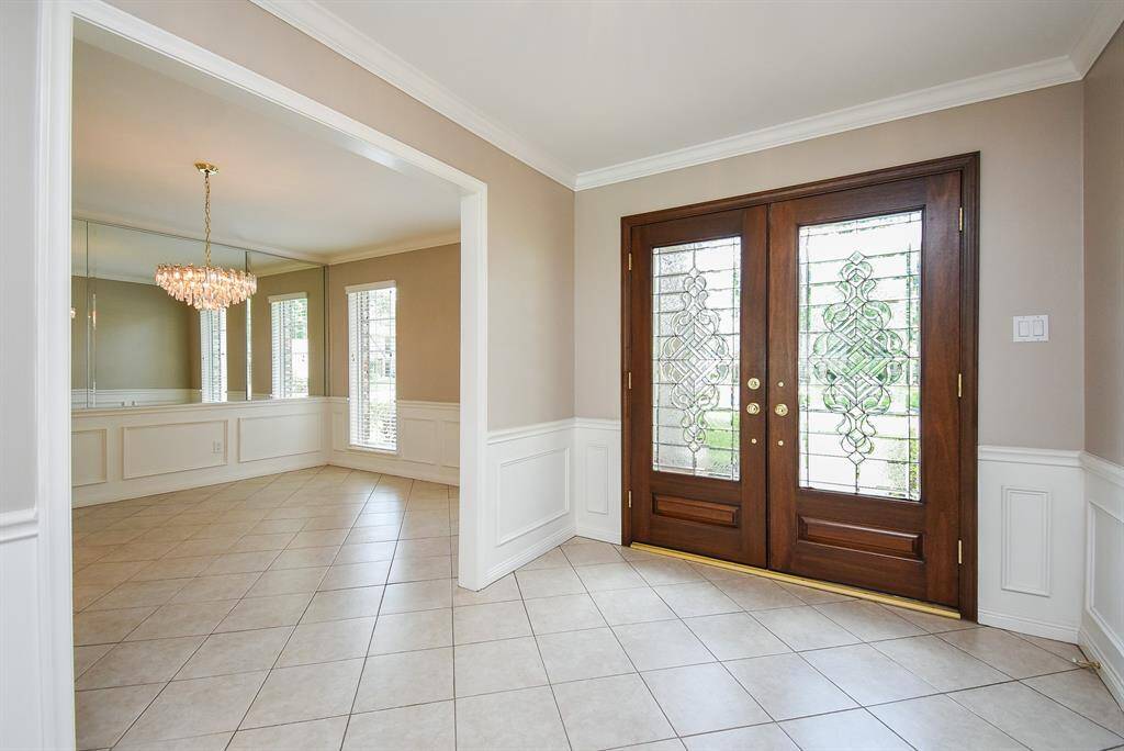 Streamlined structures grace the front entry, from the inside, beyond glass-inlaid double doors, with tranquil earth toned walls/crown molding and wide open, airy doorways to front rooms.