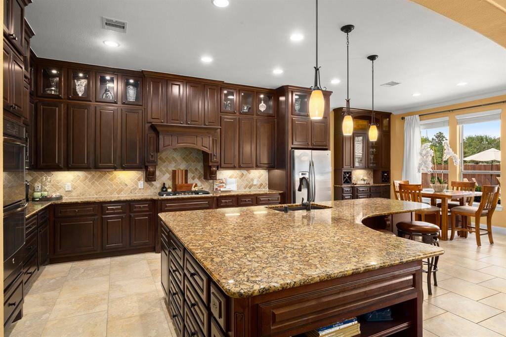 Granite counters, glass-front cabinetry, and ample storage. Butler’s pantry and walk-in pantry for next-level organization.