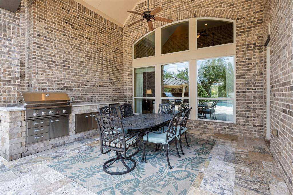 Fire up the grill in the covered outdoor kitchen, fully equipped with a granite countertop, refrigerator, and plenty of prep space.