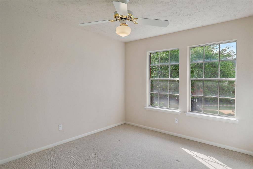 Bright and inviting secondary bedroom with large windows offering serene views.