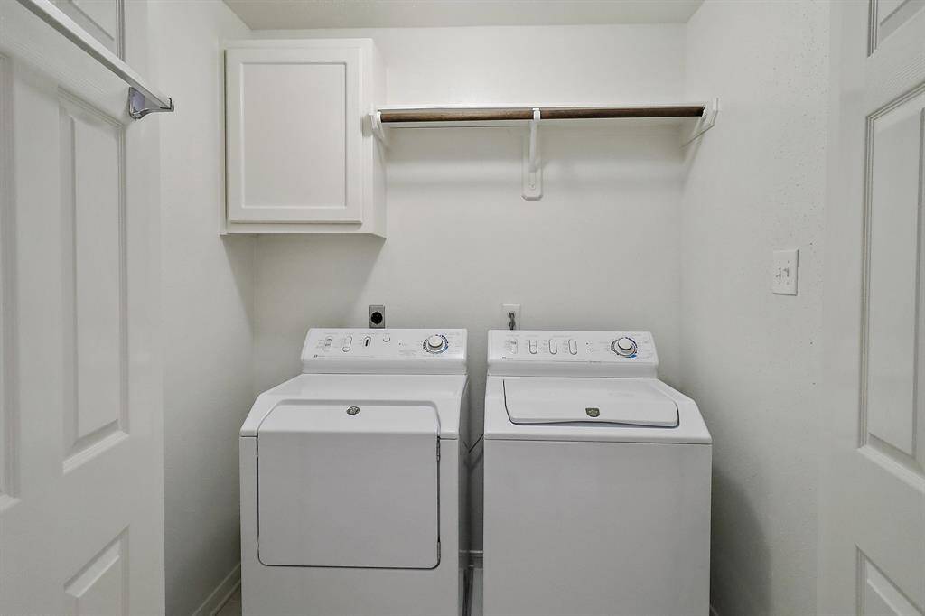 Efficient utility room with washer, dryer, and ample storage. Perfect for all your laundry needs.