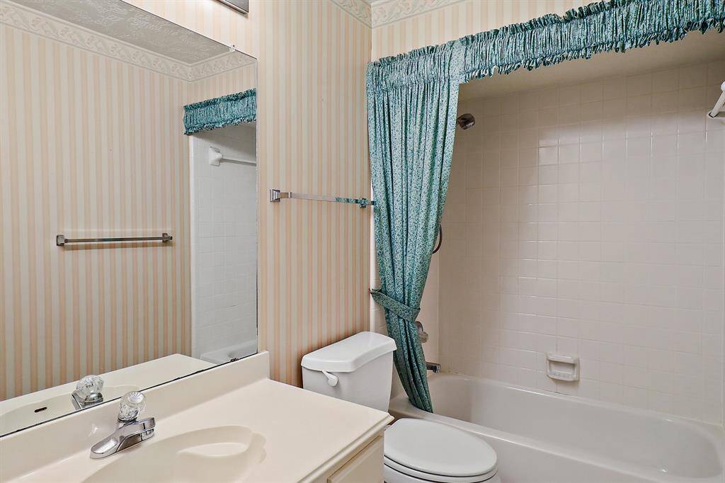 Cozy upstairs bathroom with a full tub and classic charm.