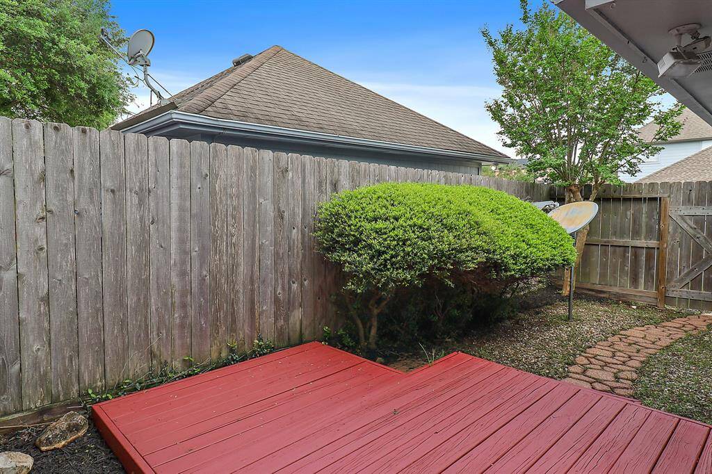 Cozy and private porch area, perfect for relaxing or entertaining, surrounded by a charming wooden fence.