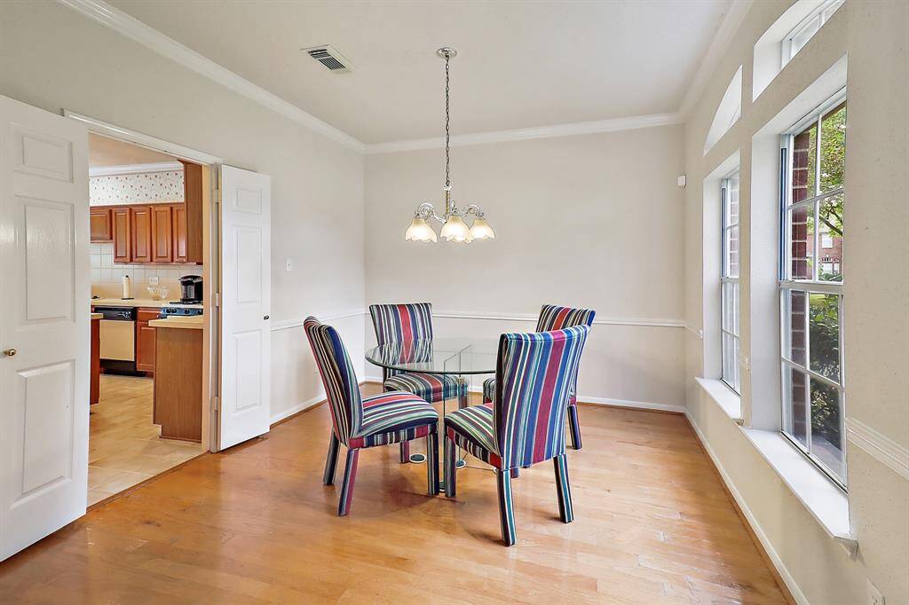Bright and inviting dining space with large windows and elegant wood flooring, perfect for intimate gatherings.