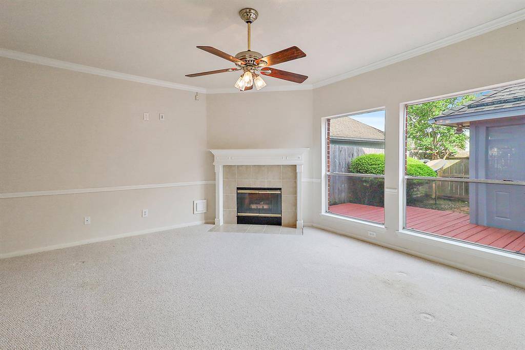 Bright family room with large windows overlooking a serene backyard patio.