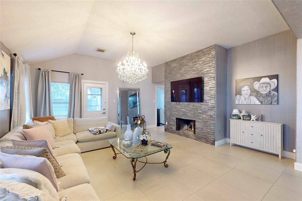 A cozy fireplace with a sleek stone accent wall. A perfect place for relaxation and entertaining.