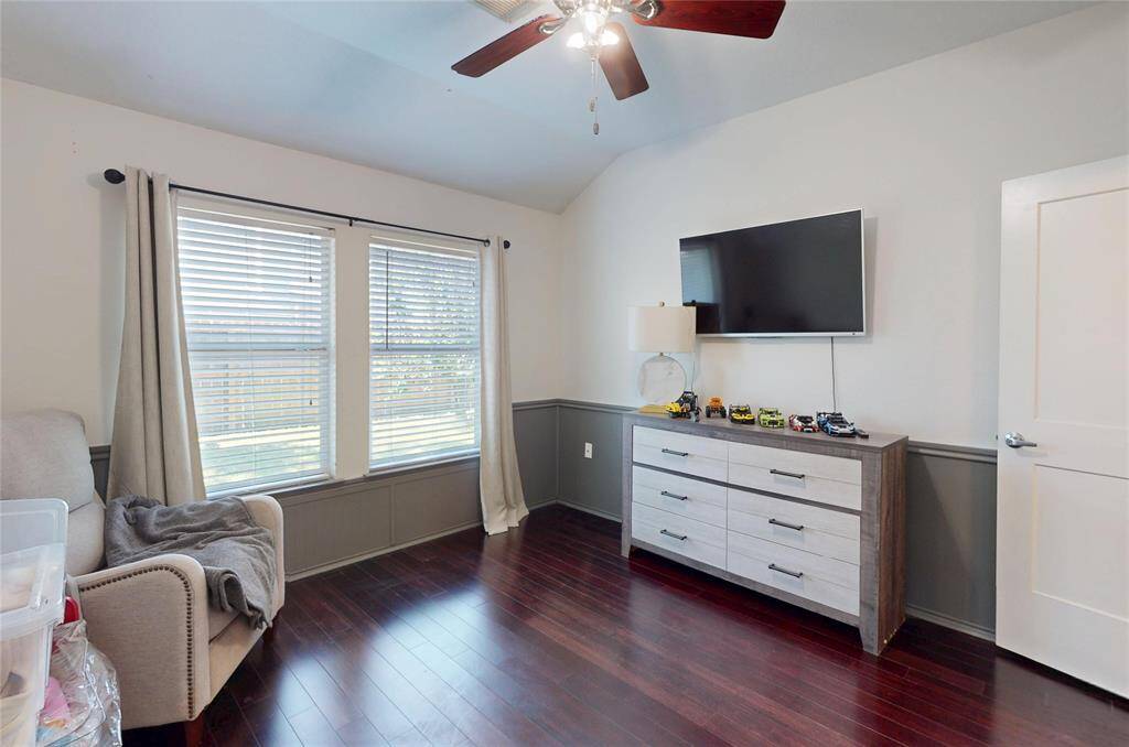 This room features hardwood floors, a ceiling fan, and two large windows with blinds, providing plenty of natural light. Neutral colors create a cozy atmosphere. This room could be used as a bedroom, additional seating area, office space or creative space. The possibilities are endless.