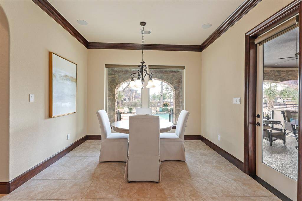 This charming Breakfast Room, with a large window showcasing views of the Backyard Oasis, offers easy access to the Covered Patio through a door that leads you to the pool and spa.