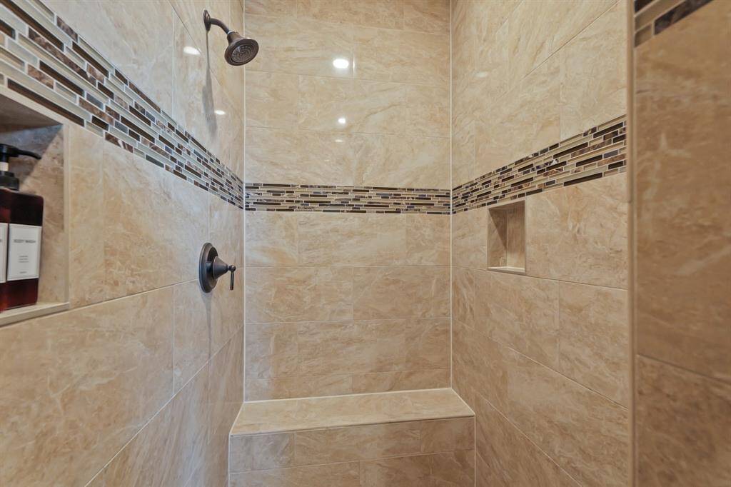 The large Primary Bathroom Shower is a true highlight, featuring large-format tiles, a bench for comfort, offering a perfect combination of luxury and practicality.