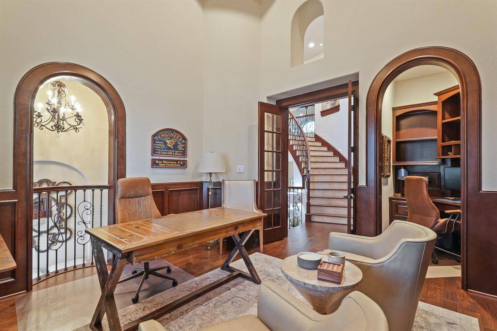This sophisticated Home Office features rich wood accents, arched doorways, and French doors for a grand entrance. Built-in shelving, a private study nook, and an open balcony overlooking the first floor create a perfect blend of style and productivity.