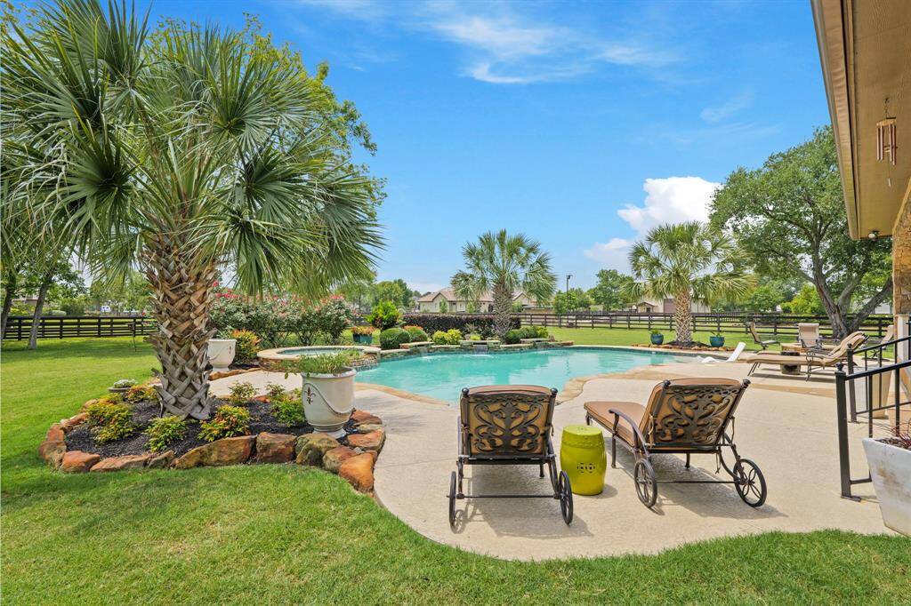 This resort-style backyard boasts a sparkling pool & spa, complete with tanning ledge, 3 water features, offering a serene and private retreat.