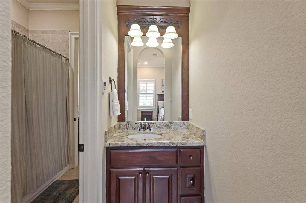 Jack & Jill Bathroom featuring a charming vanity with a granite countertop, & offers ample storage for toiletries.