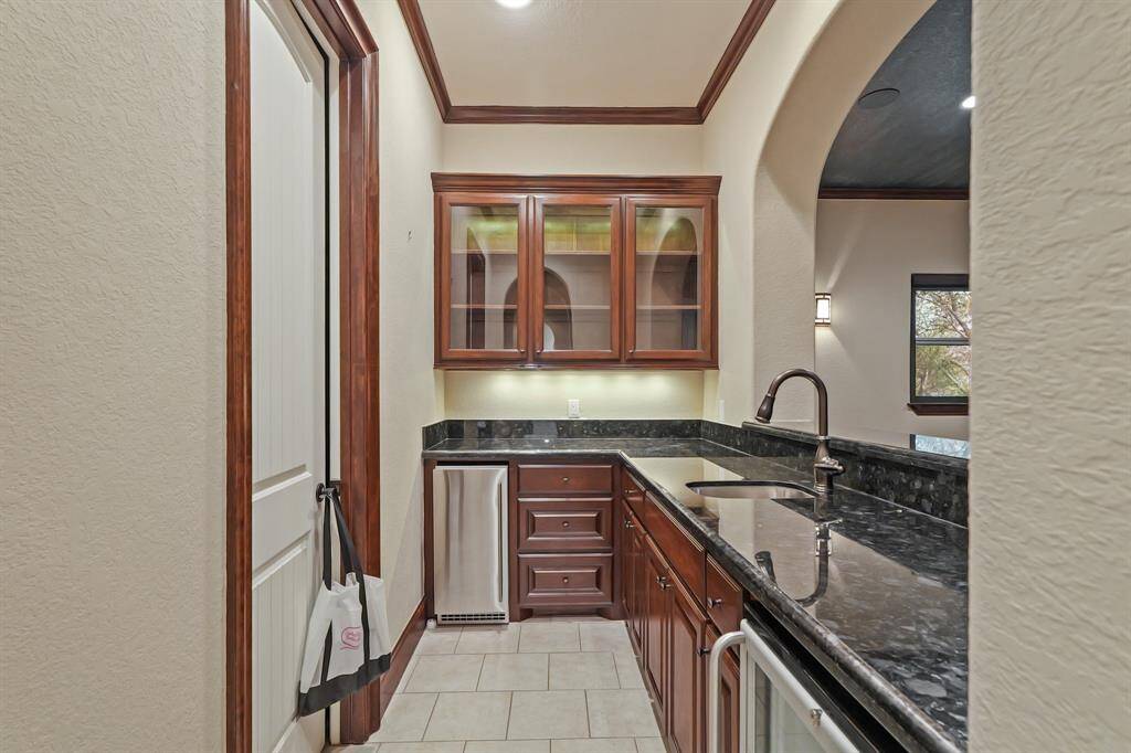 This upstairs Bar overlooks the Media Room and is equipped with an Icemaker, Mini Fridge, and Sink — perfect for entertaining in style!