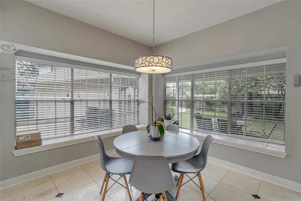 The breakfast area with a stylish light fixture, overlooking the backyard.