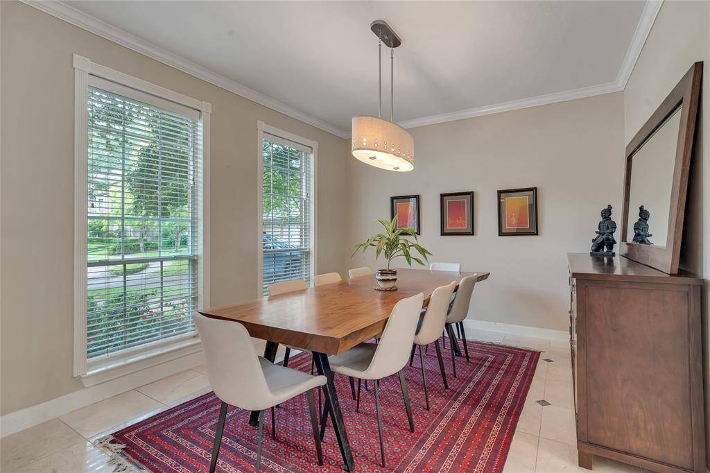 A view of the formal dining room with a contemporary light fixture and Spanish marble floors.