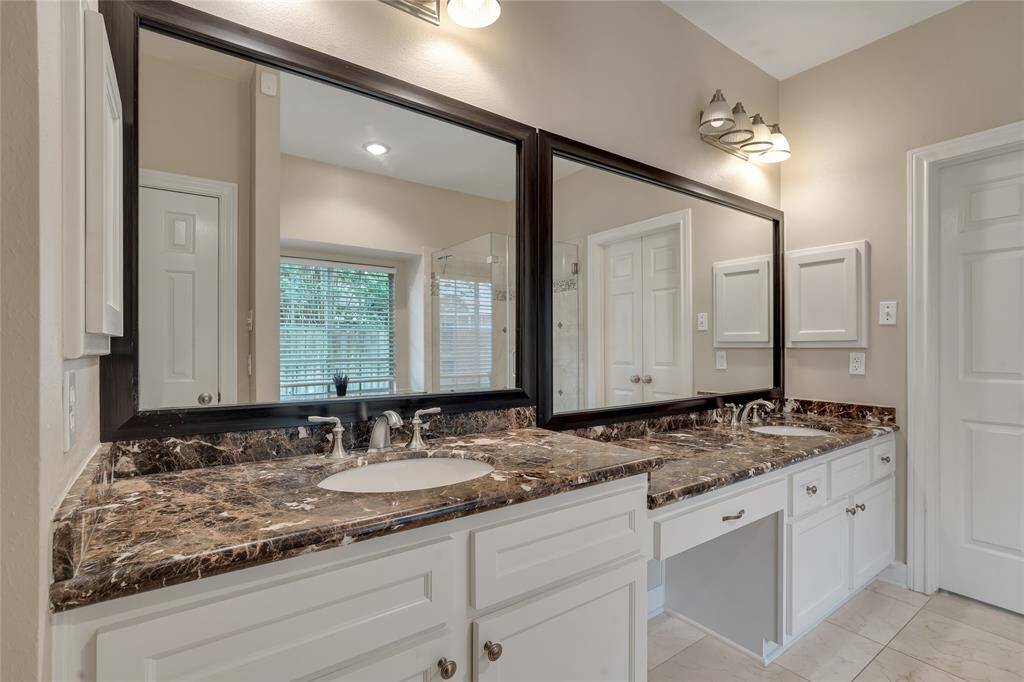 Stunning updated granite countertops and framed mirrors in the primary bathroom.