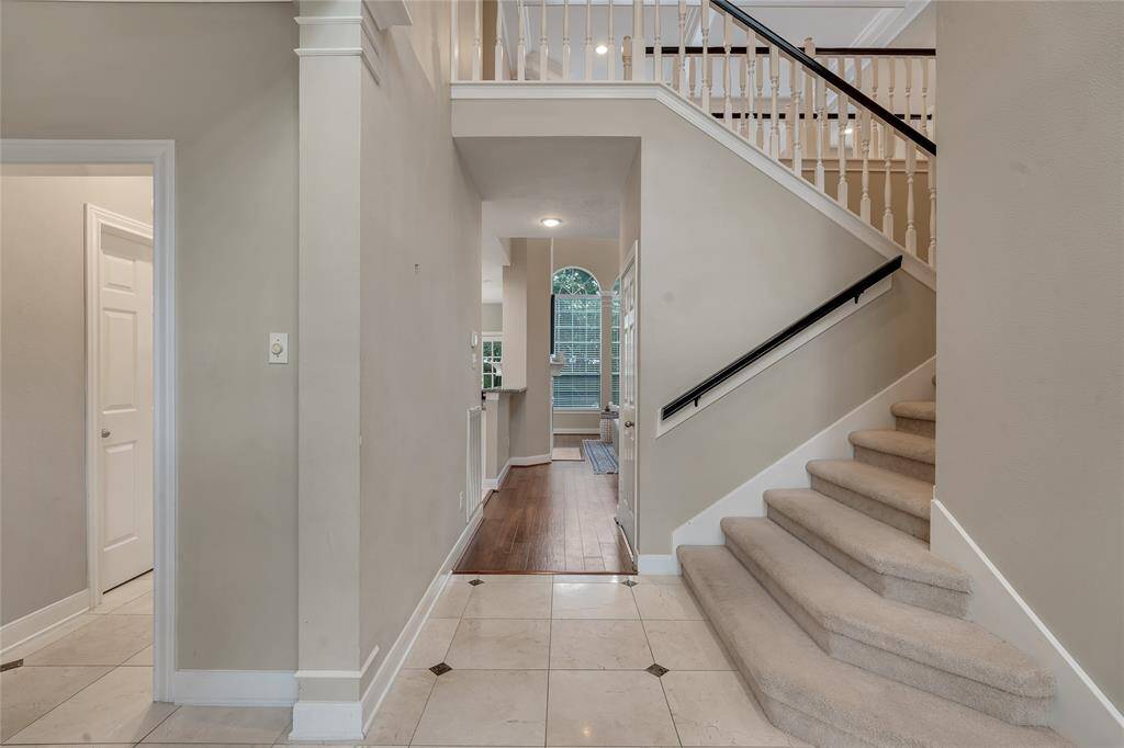 The staircase leads to the second floor with a game room, three bedrooms, and two bathrooms.