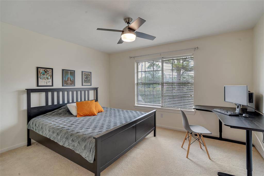 One of three secondary bedrooms. With a modern ceiling fan and a walk-in closet.