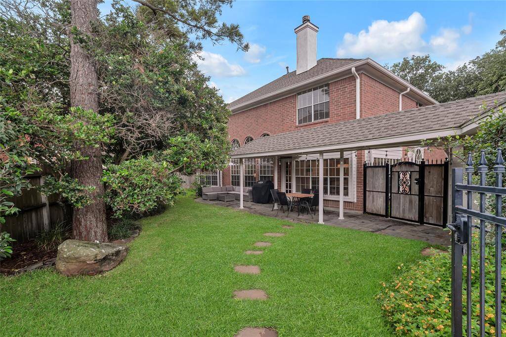 Spacious grass area in the fenced off backyard.